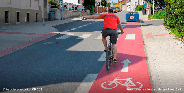 Cyklistovi, který dává znamení o změně směru jízdy proto, aby mohl přejet z vyhrazeného jízdního pruhu pro cyklisty do průběžného pruhu, řidič jedoucí v přilehlém pruhu: